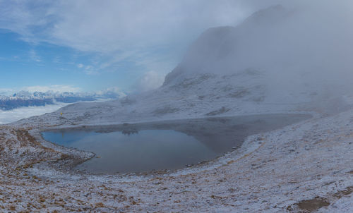 Heart-shaped pond on the border between italy and austria after a snowfall