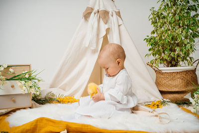 Portrait of woman sitting on bed at home