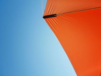 Low angle view of umbrella against clear blue sky