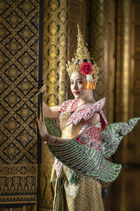 Young woman standing with umbrella in traditional clothing