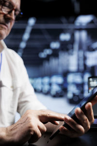 Midsection of man using mobile phone