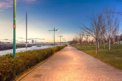 Illuminated footpath against sky at dusk