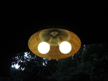 Low angle view of illuminated lamp against clear sky at night