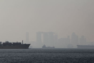 Scenic view of sea by city against sky