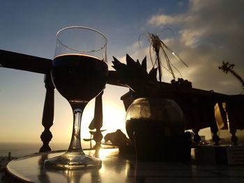 Close-up of beer on table against sky during sunset
