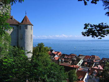 Scenic view of sea and buildings against clear blue sky