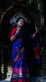 Portrait of woman standing against trees