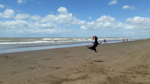 Woman on beach against sky