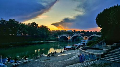 Bridge over river in city against sky
