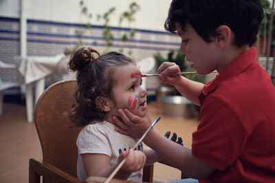 Children playing in an inner courtyard and painting with water paints
