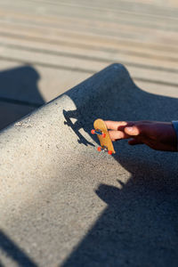 Riding a mini skateboard or fingerboard on outdoors ramp