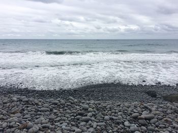 Pebbles on beach against sky