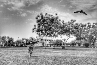 Boy flying kite against sky