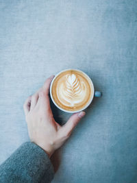 Close-up of hand holding coffee cup