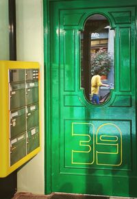 Man looking through window of door