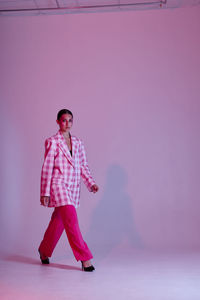 Young woman standing against wall