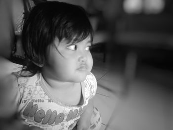 Close-up of cute girl looking away at home