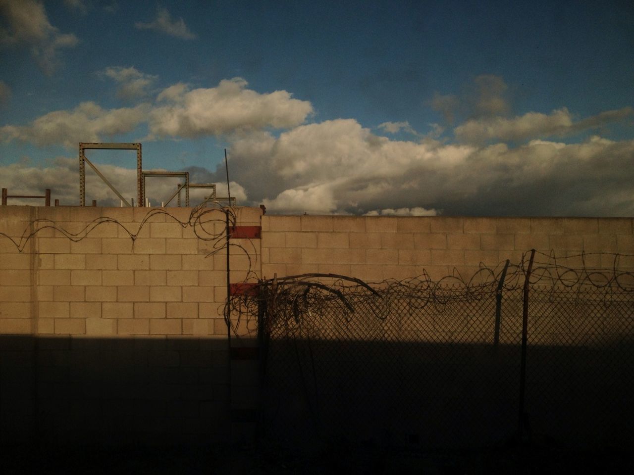 sky, cloud - sky, built structure, fence, architecture, cloud, railing, protection, sunset, safety, building exterior, outdoors, no people, metal, cloudy, silhouette, nature, sunlight, wall - building feature, security