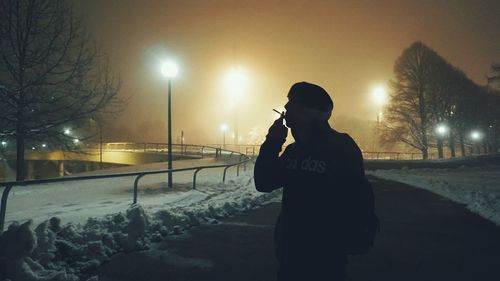 Man standing on street at night during winter