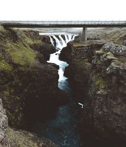 Scenic view of waterfall amidst mountains