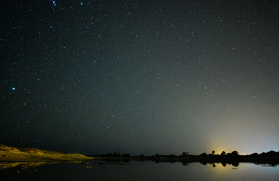 Scenic view of lake against star field at night