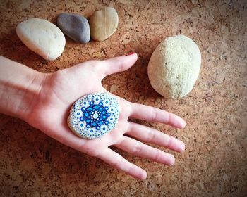 Directly above shot of hand holding designed pebble