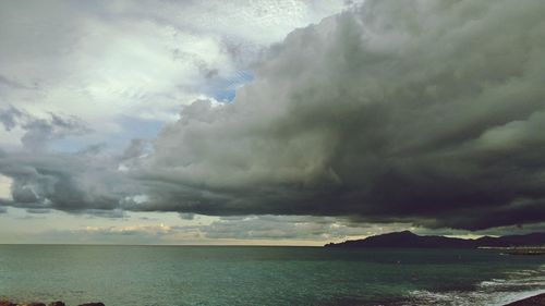 Scenic view of sea against storm clouds
