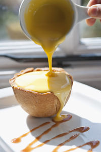 Custard poured over apple tart at british pub