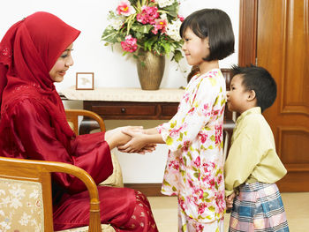 Mother and daughter holding hands at home