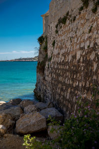 Rocks by sea against sky