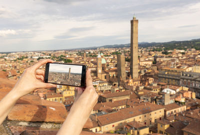 High angle view of cityscape and mobile phone against sky