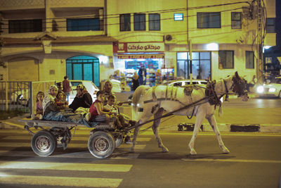 Side view of people riding bicycle on city street