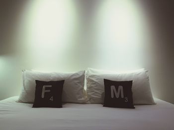 Pillows and cushions on bed in illuminated bedroom