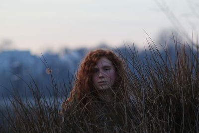 Portrait of woman on grass against sky