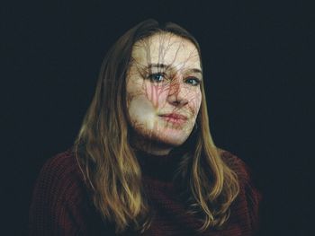 Portrait of woman against black background