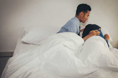 Rear view of a man sleeping on bed