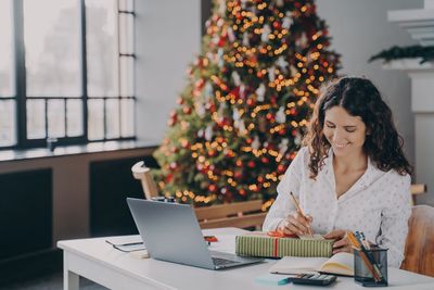 Smiling businesswoman writing on gift card at office