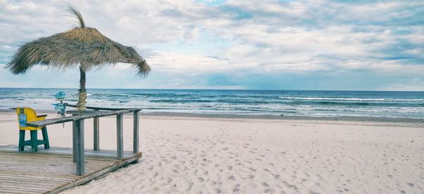 Lifeguard hut on beach against sky