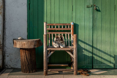 View of shoes on wooden chair outdoors