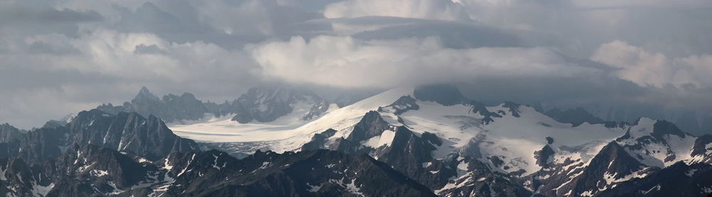 Panoramic view of snowcapped mountains against sky