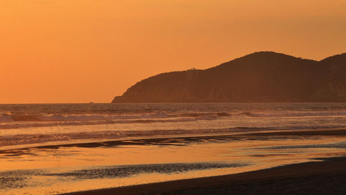 Scenic view of sea against orange sky