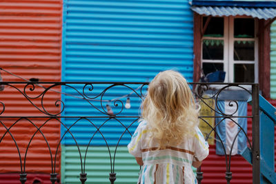 Rear view of woman looking through window