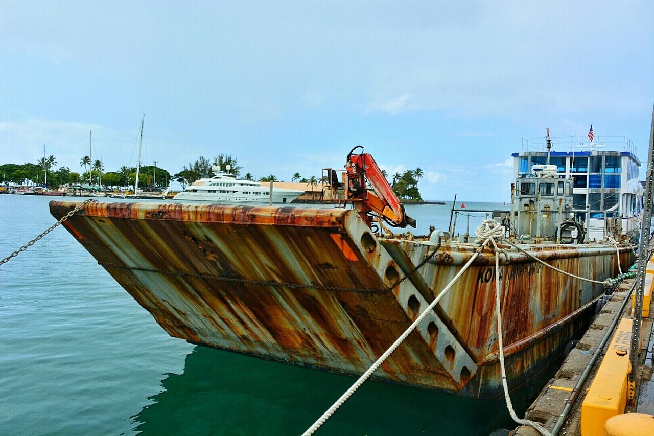 nautical vessel, water, boat, transportation, moored, clear sky, mode of transport, blue, rope, sea, wood - material, sky, built structure, day, railing, no people, outdoors, pier, rusty, nature