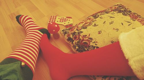 Low section of woman sitting on bed at home