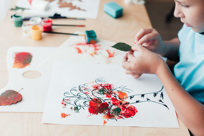 Midsection of girl drawing on table