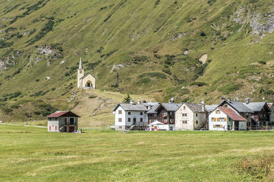 House on field by houses and mountains