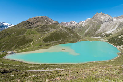 Scenic view of lake and mountains against blue sky