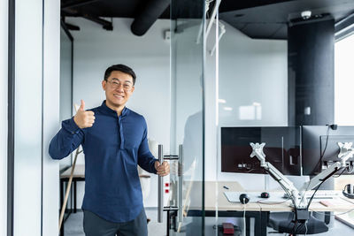 Portrait of young man standing in office