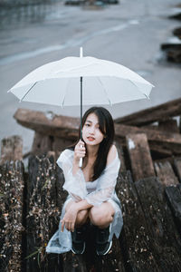 Portrait of woman sitting in rain