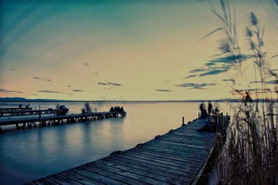 Pier over sea against sky during sunset